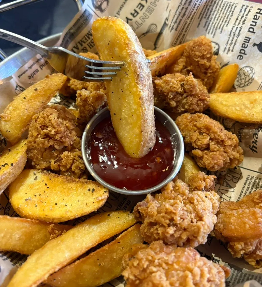 A plate of crispy boneless chicken and wedge potatoes