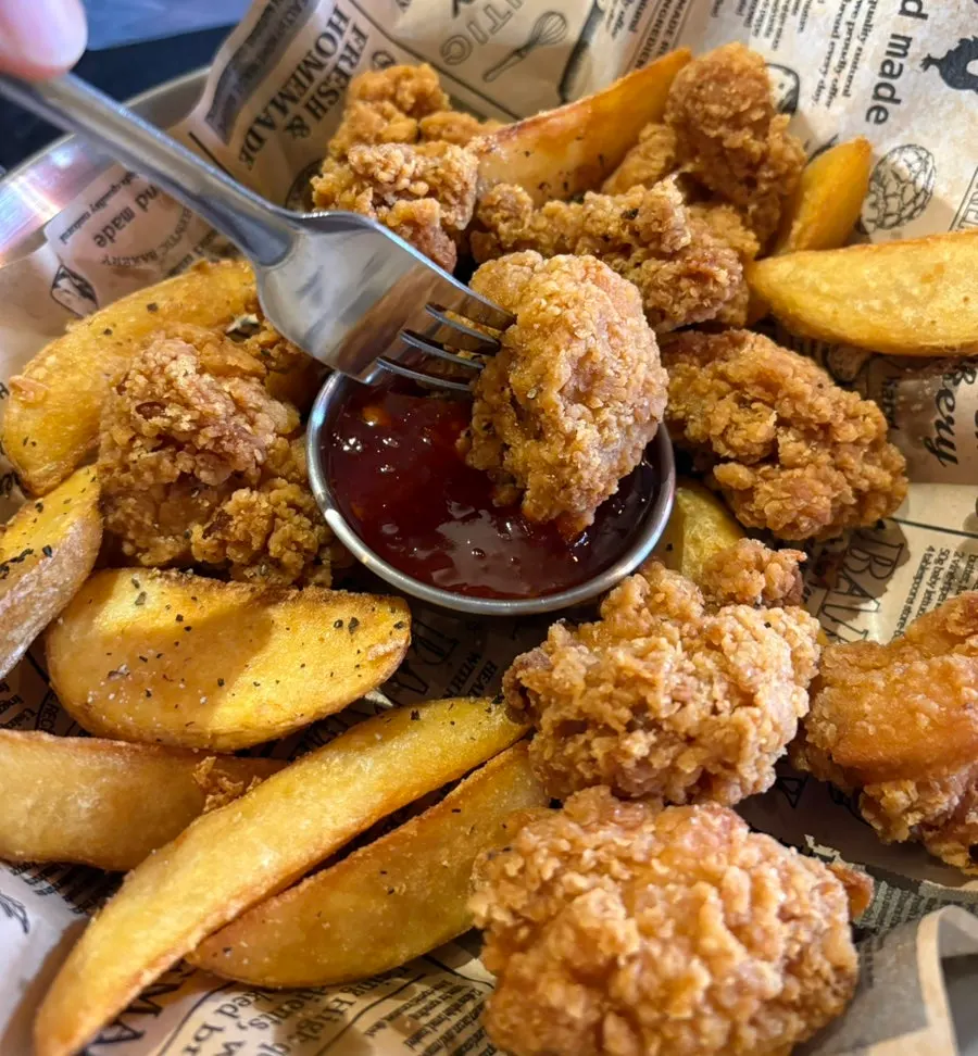 Table with boneless chicken and draft beer being enjoyed together