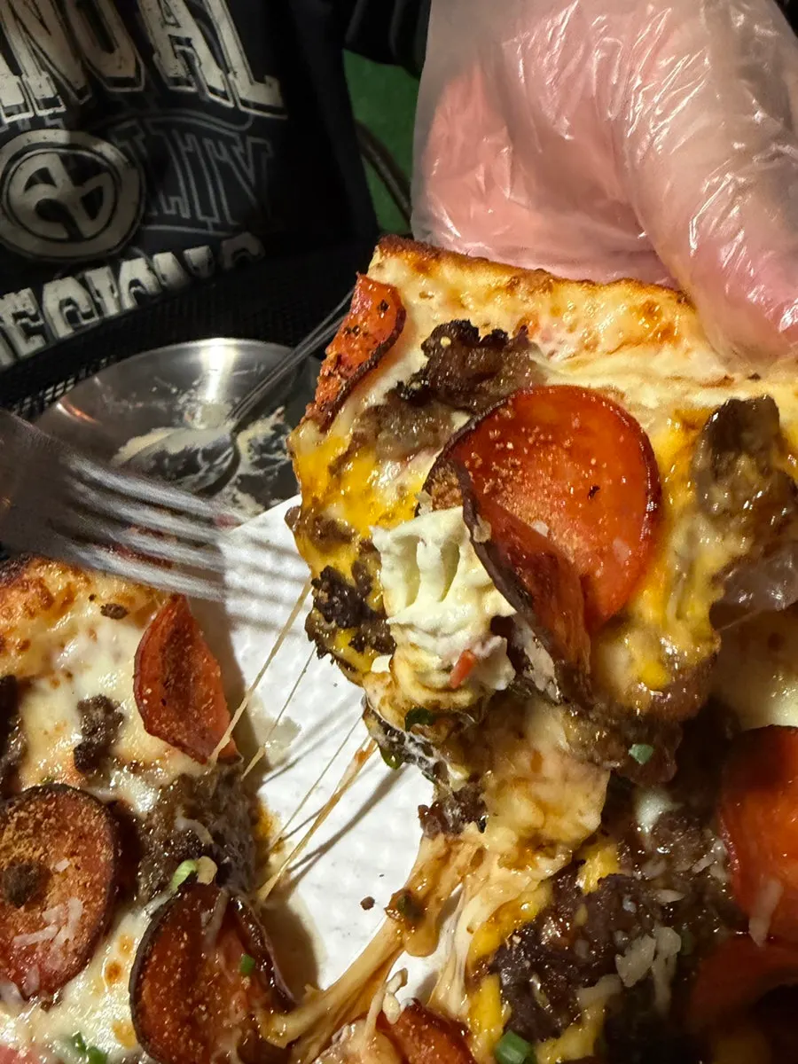 A slice of half-and-half pizza with stretching cheese