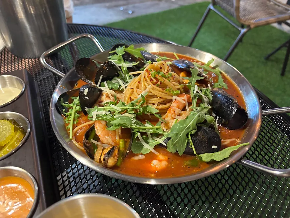 Pizza and pasta set out on the outdoor table