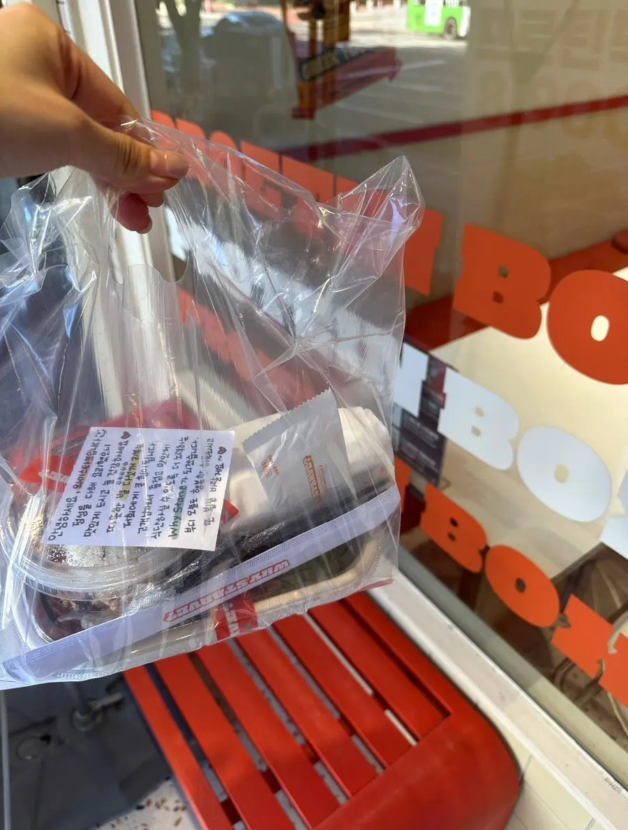 Takeout bag held up in front of the store
