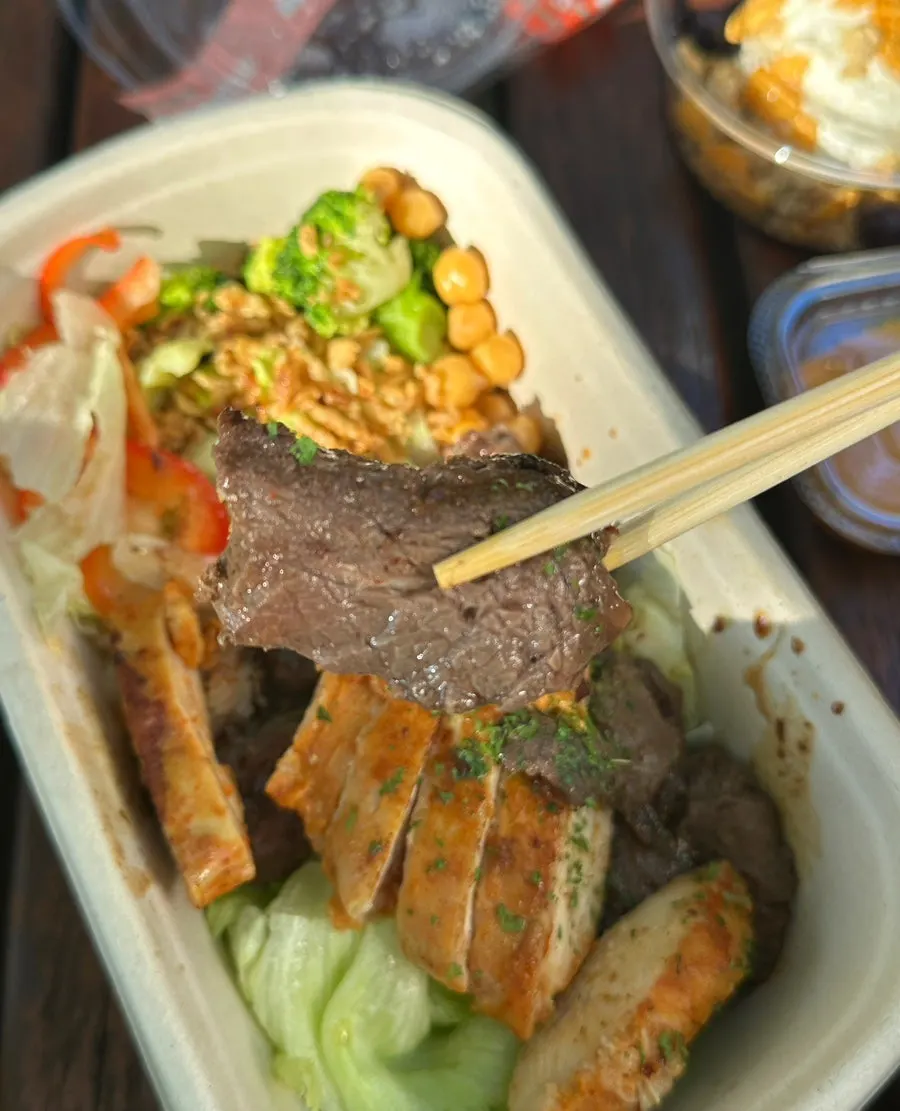 A bite of the protein box dipped in sauce