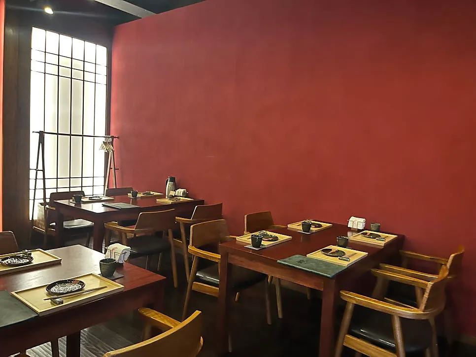 Interior of Kosei with wood-toned tables and red walls