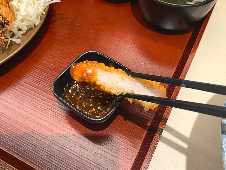 A piece of loin katsu dipped in sauce