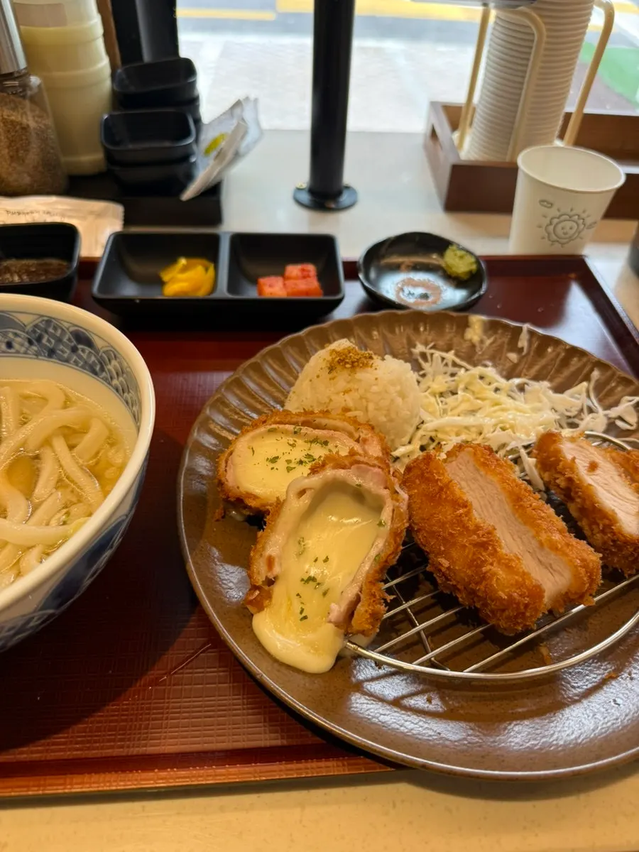 A piece of tonkatsu with cheese stretching to the last bite