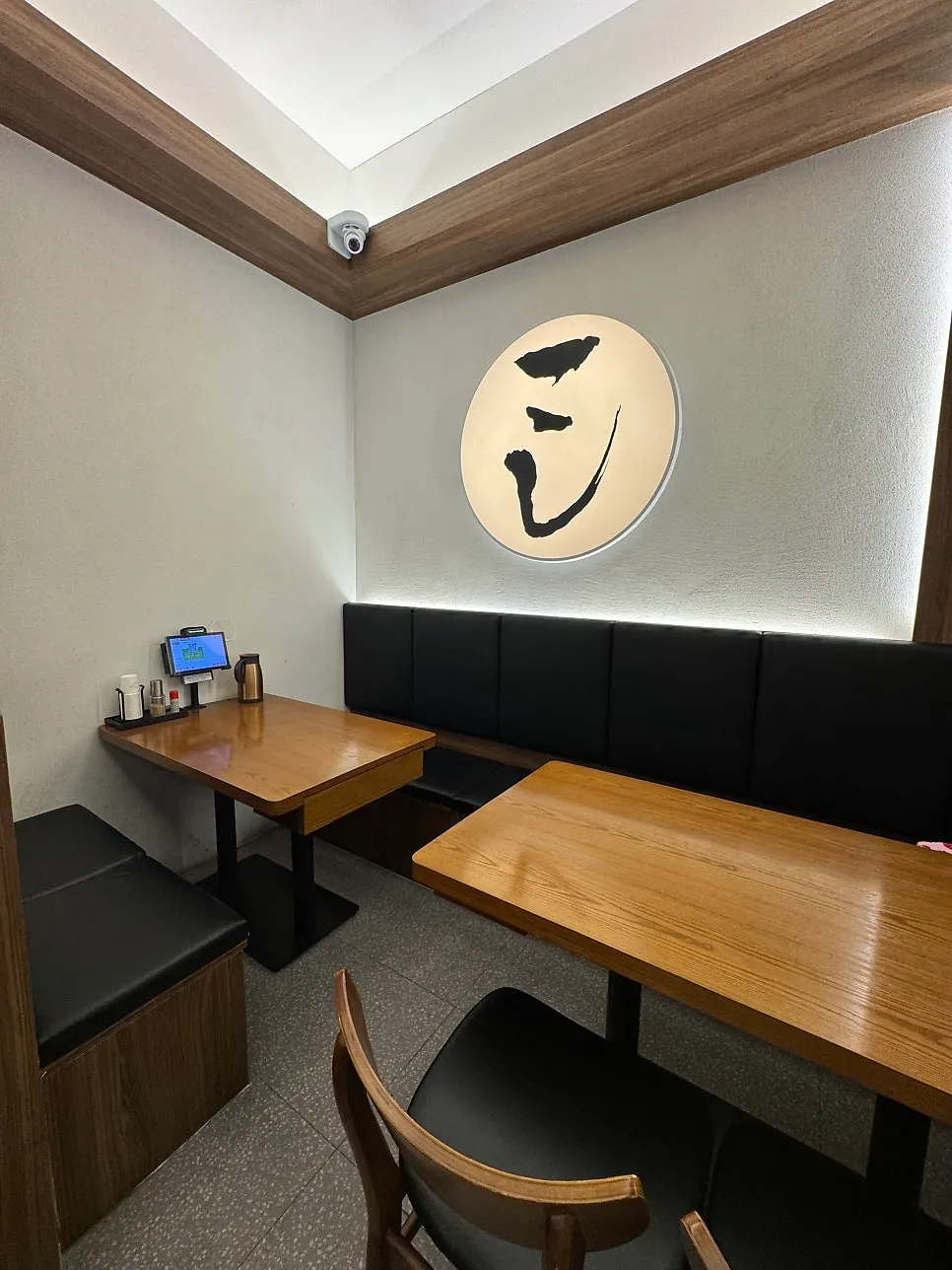 Wood tables and black chairs spaced generously apart