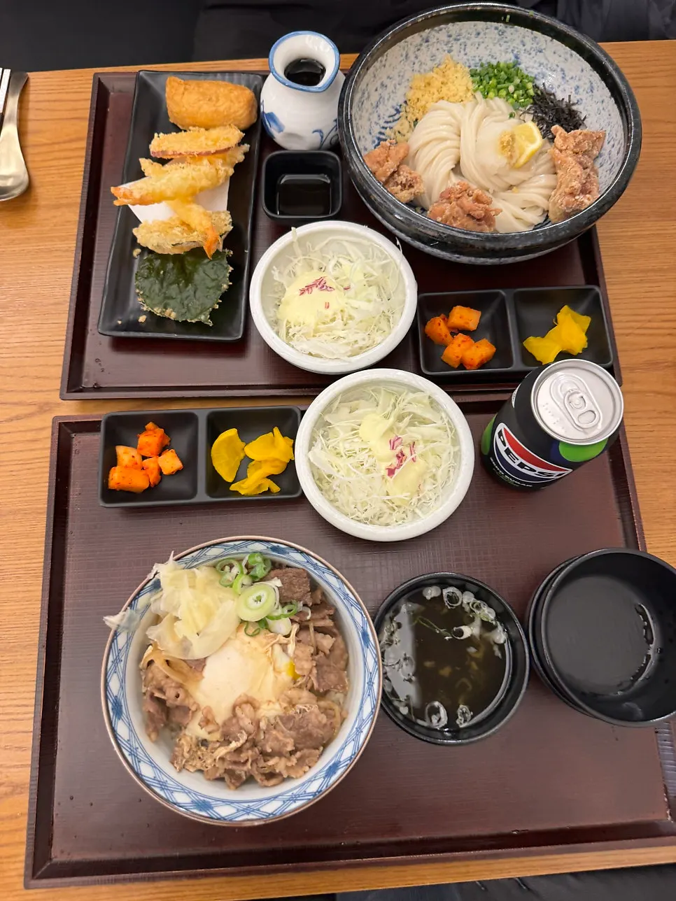 A table for two packed with udon, gyudon, and tempura