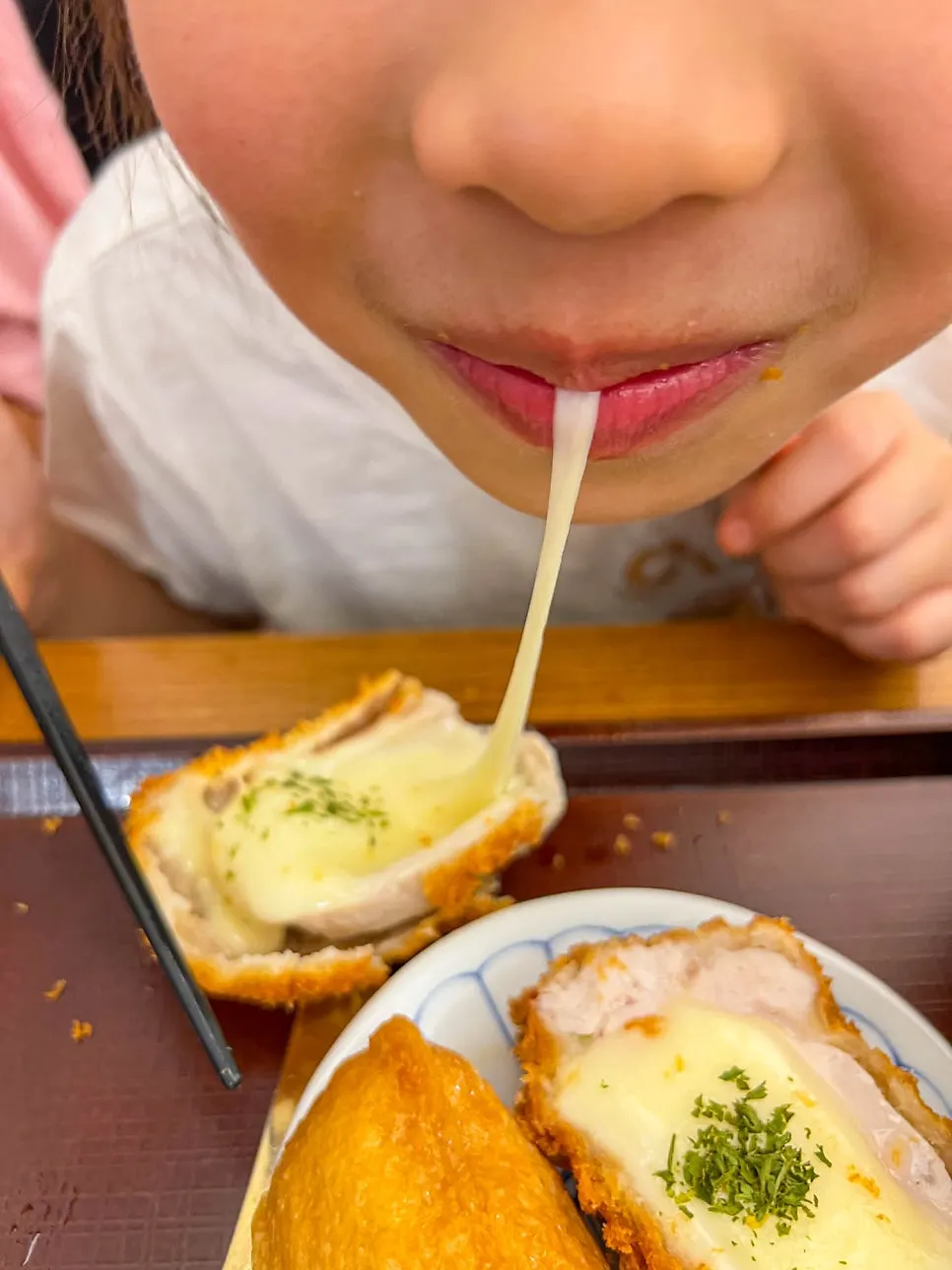 A bite of cheese tonkatsu dipped in sauce