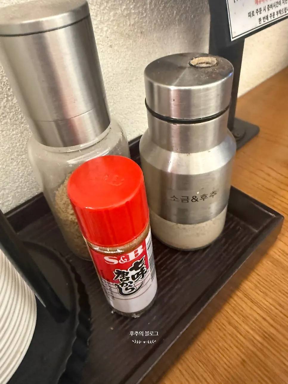 Salt, pepper, sesame, and shichimi seasonings set on the table