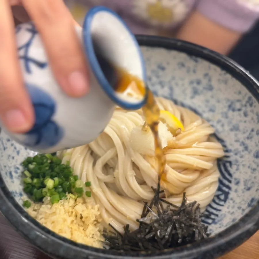 Handmade udon noodles lifted with chopsticks