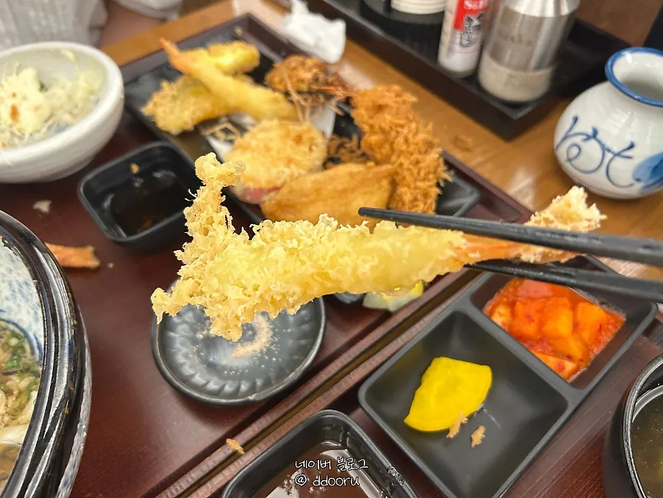 Shrimp tempura placed on top of the udon