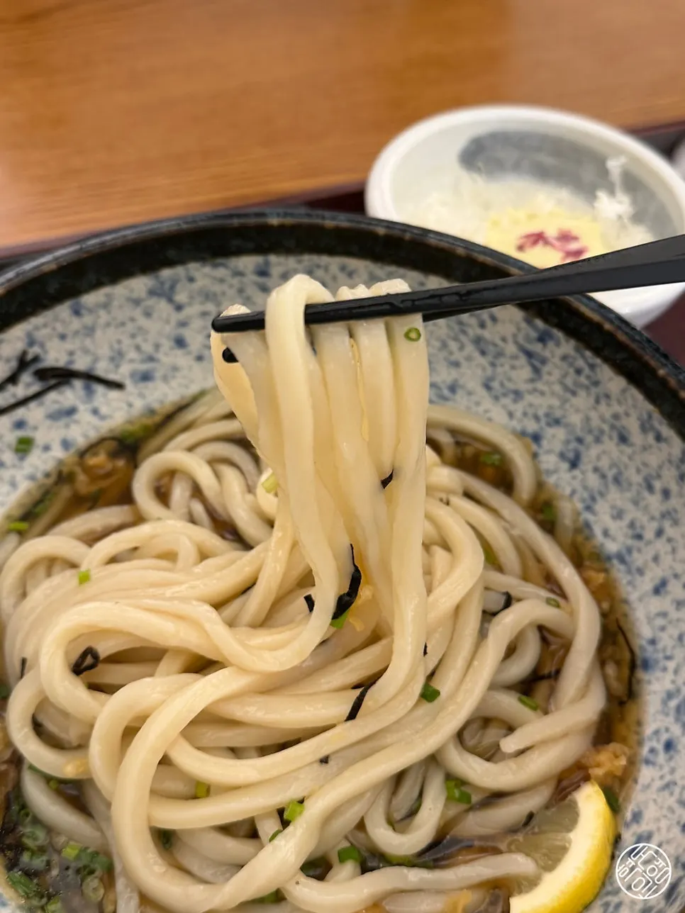 Bukkake udon noodles lifted up after pouring in the broth
