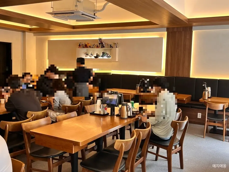 Black, white, and wood-tone interior of Kosi Konkuk University Branch