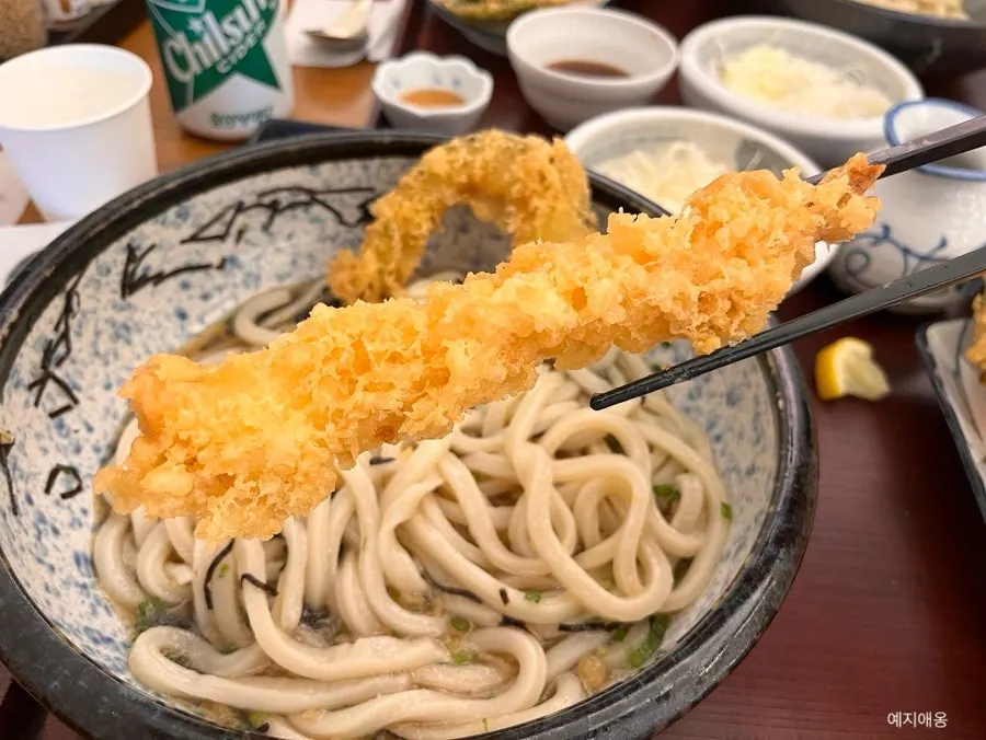 Large shrimp tempura and sweet pumpkin tempura on top of the udon