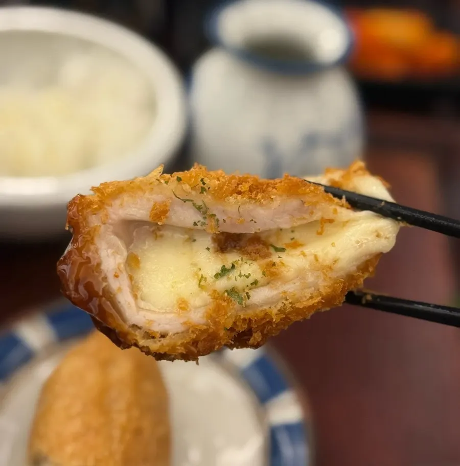 Cross-section of cheese katsu with stretchy mozzarella cheese