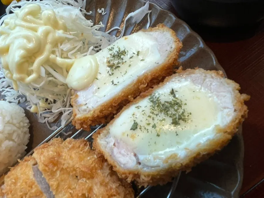Cheese oozing out of a cut cheese katsu