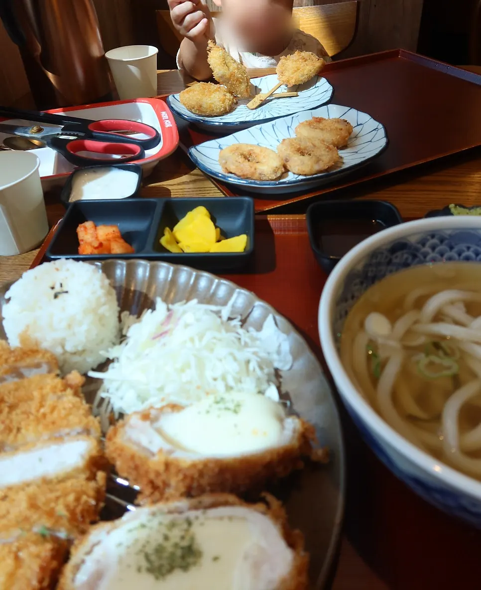 Baby holding and eating lotus root kushikatsu herself