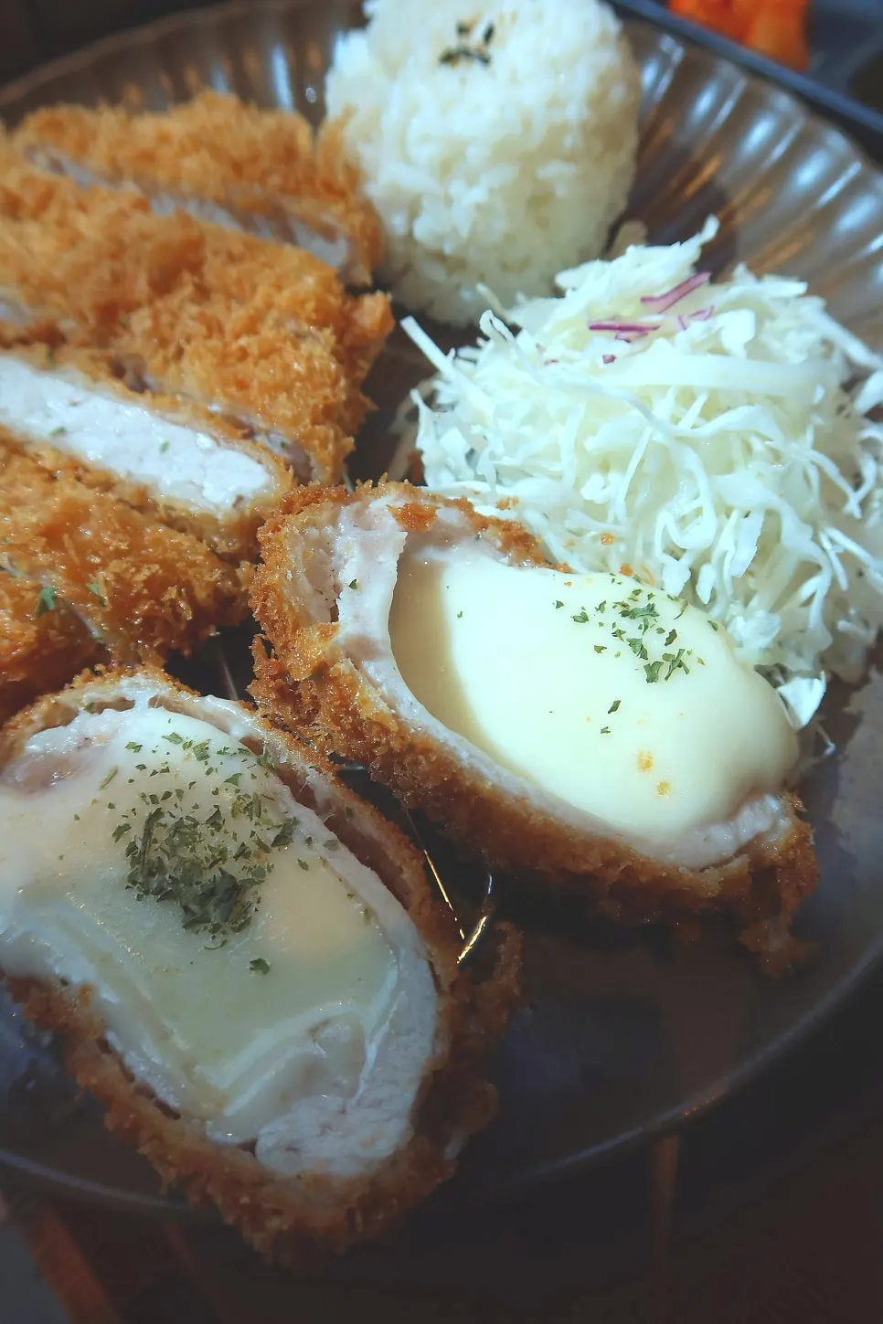 Vertical shot of baby eating tonkatsu at the table