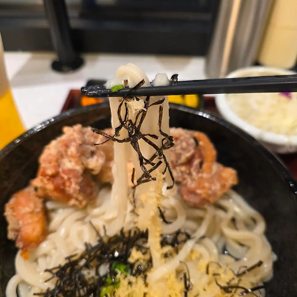 Bukkake udon noodles with sauce being poured on