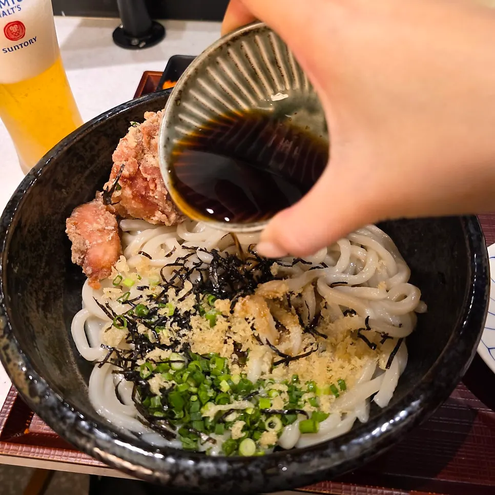 Chewy udon noodles lifted up with chopsticks