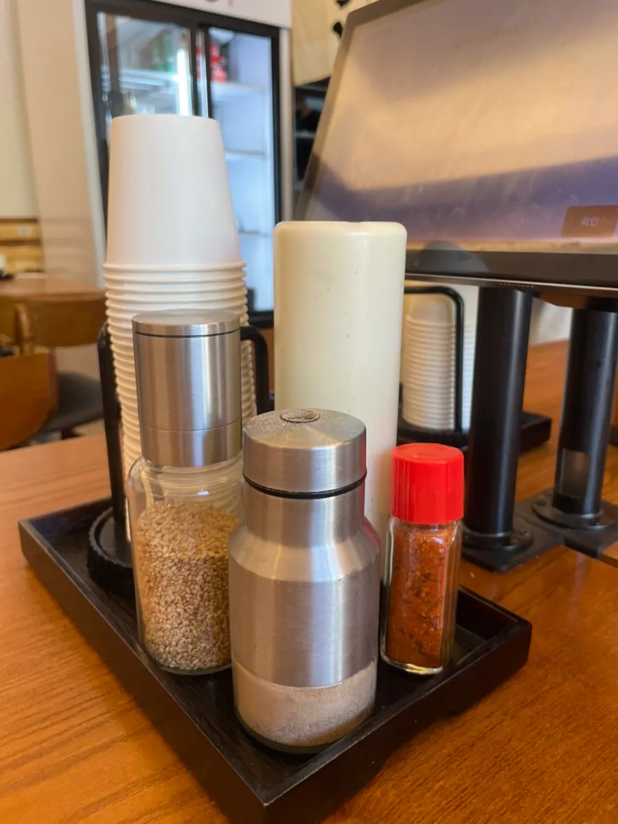 Sesame, salt, and shichimi seasonings on the table