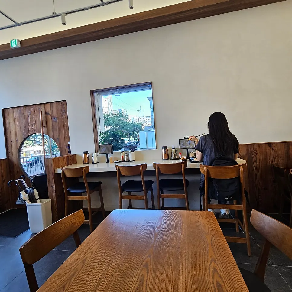 Solo dining seats lined along the wall at Kosi