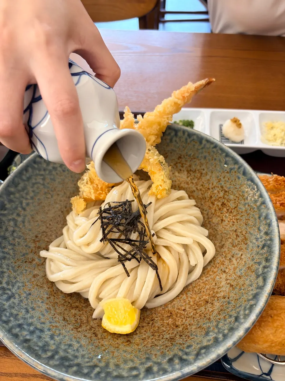 Chopsticks lifting the bukkake udon noodles