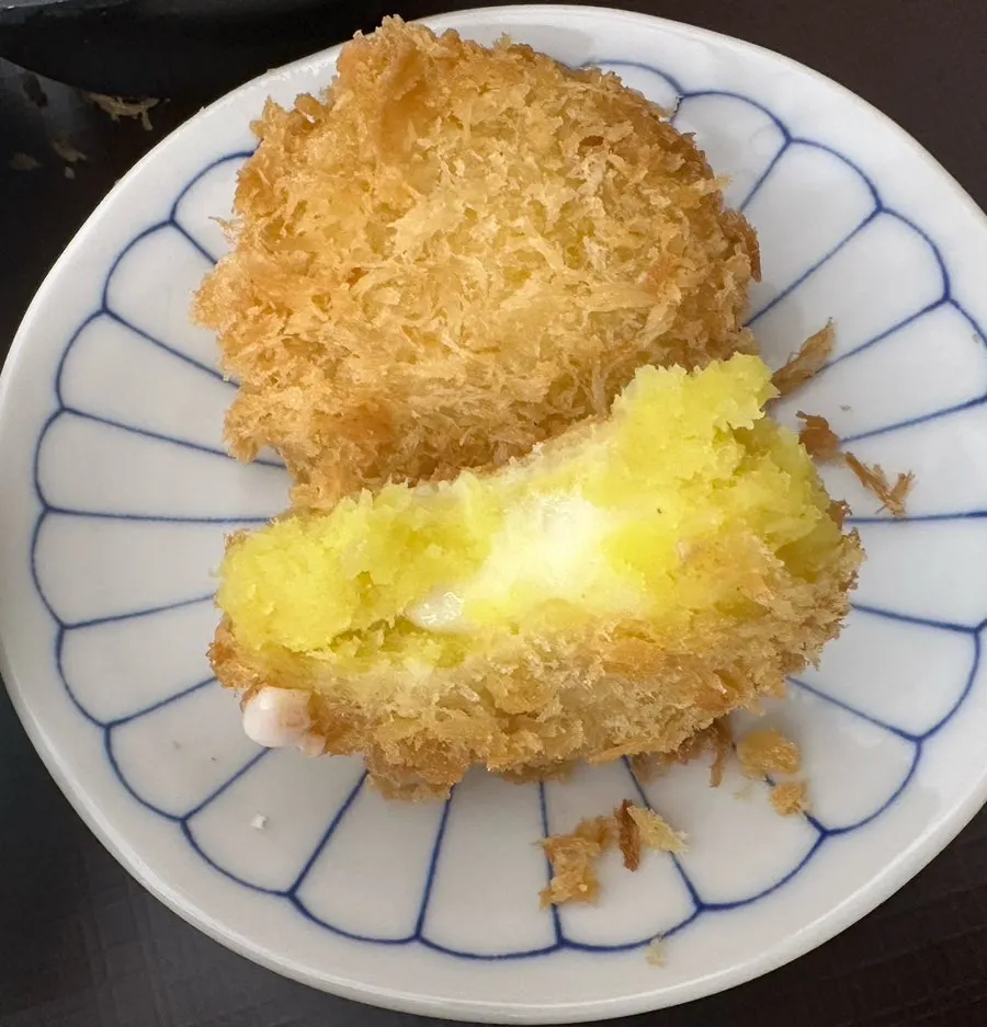 Cross-section of sweet potato cheese korokke with stretchy cheese