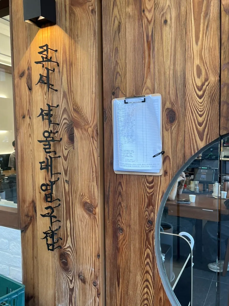 Calligraphy-style wooden sign at the entrance