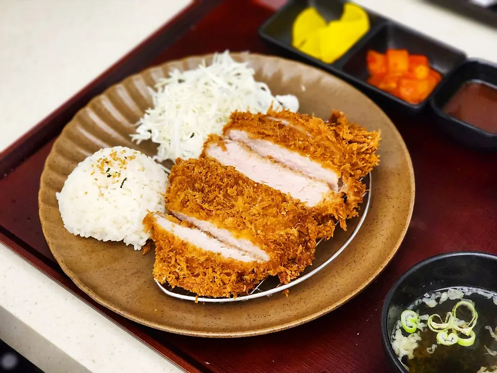 Tonkatsu served with sauce, salad, and white rice