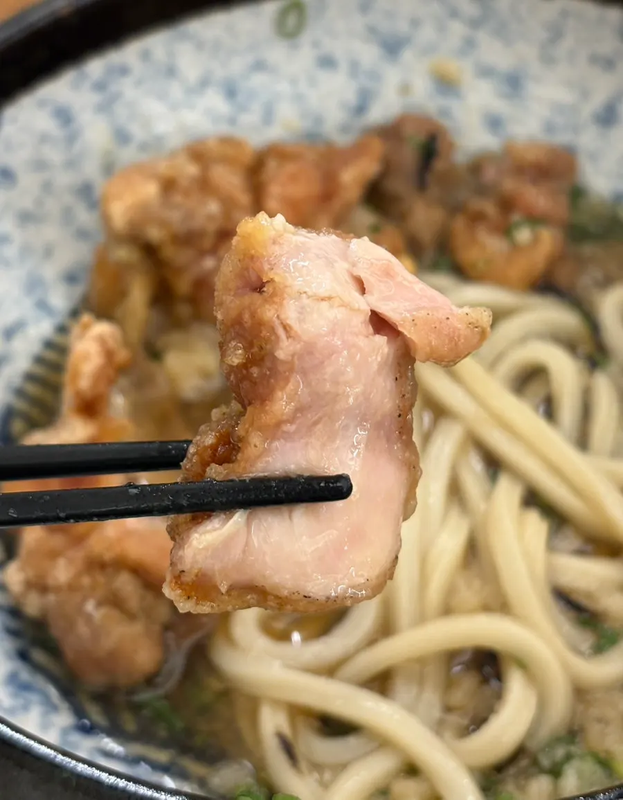 A piece of toriten fried chicken dipped in sauce