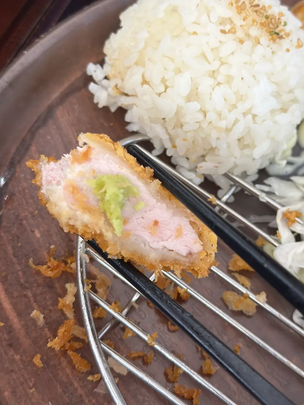 A piece of tonkatsu topped with wasabi on salt