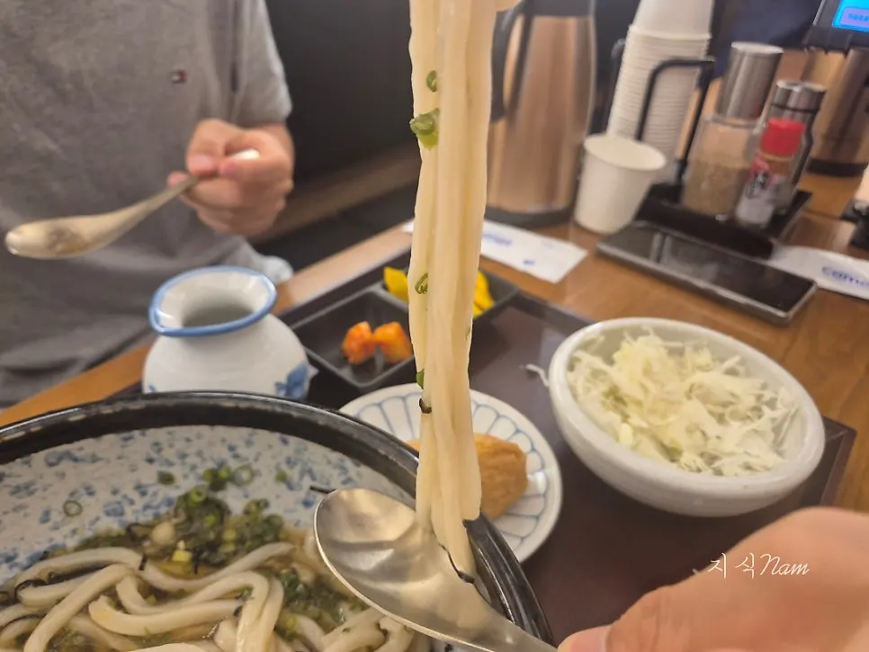 Springy udon noodles lifted with chopsticks