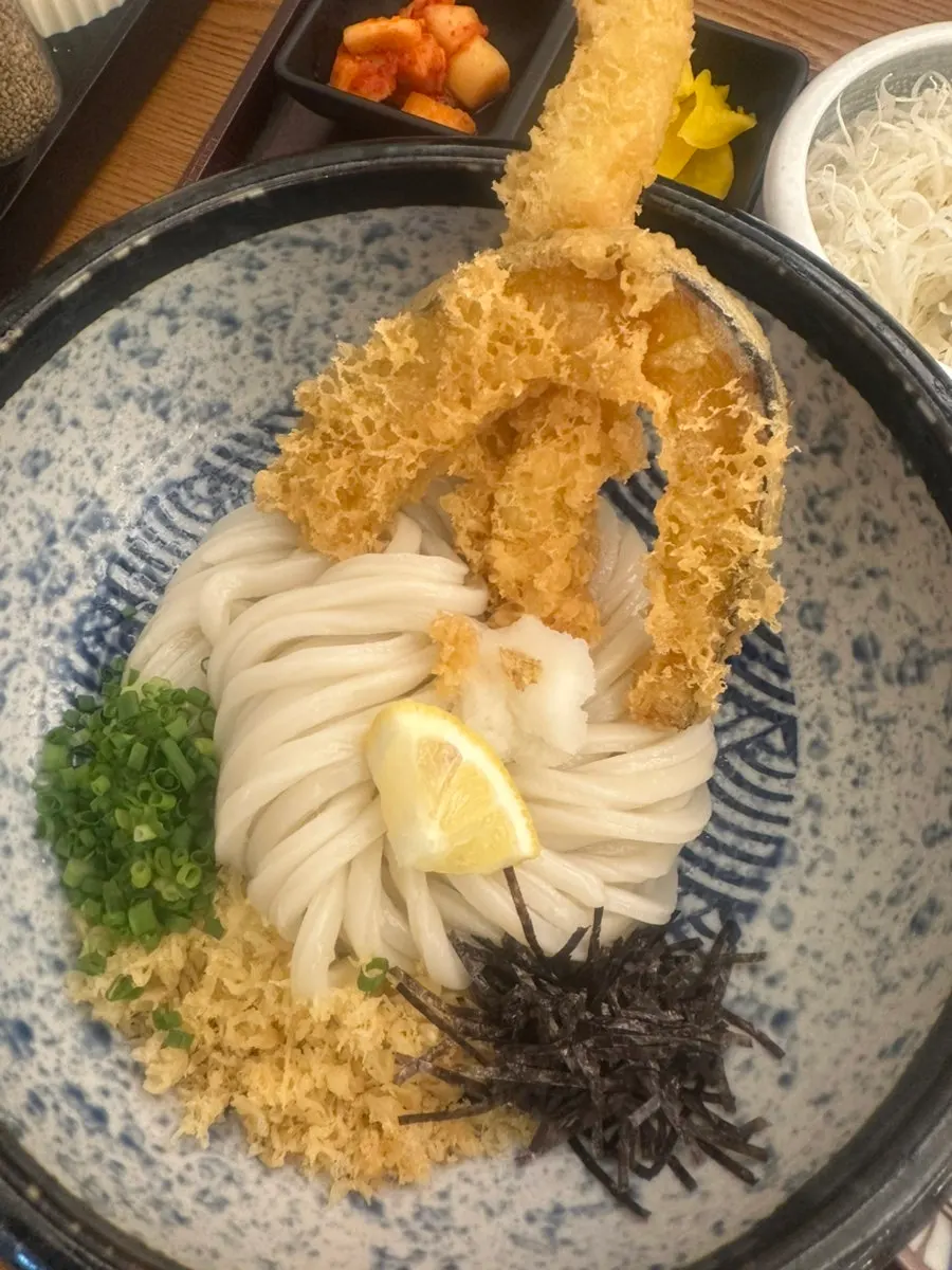 Full spread of tenbukkake udon topped with tempura