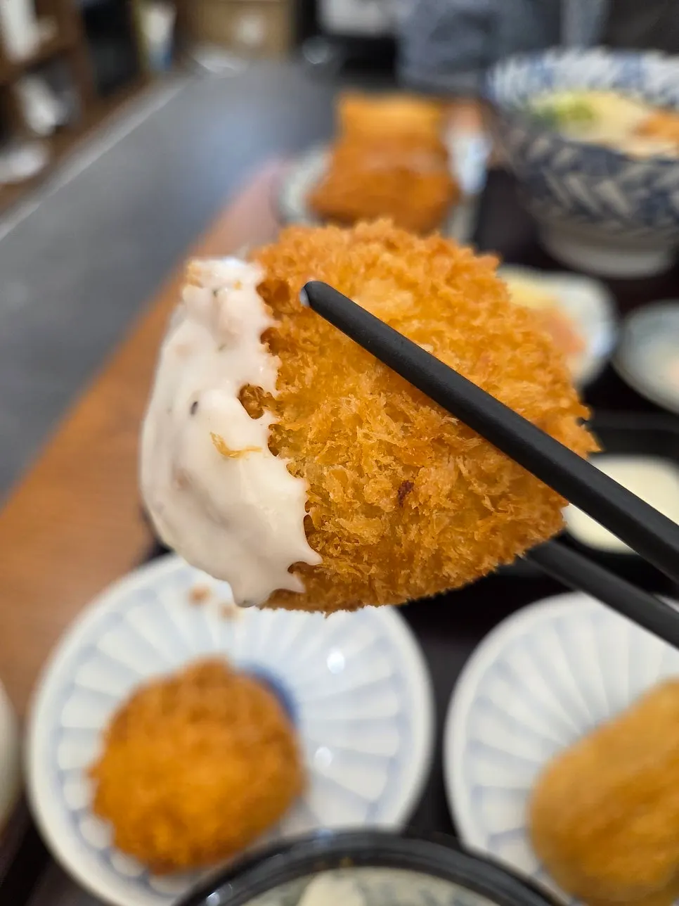 A vertical photo of the Kosi table packed with side dishes