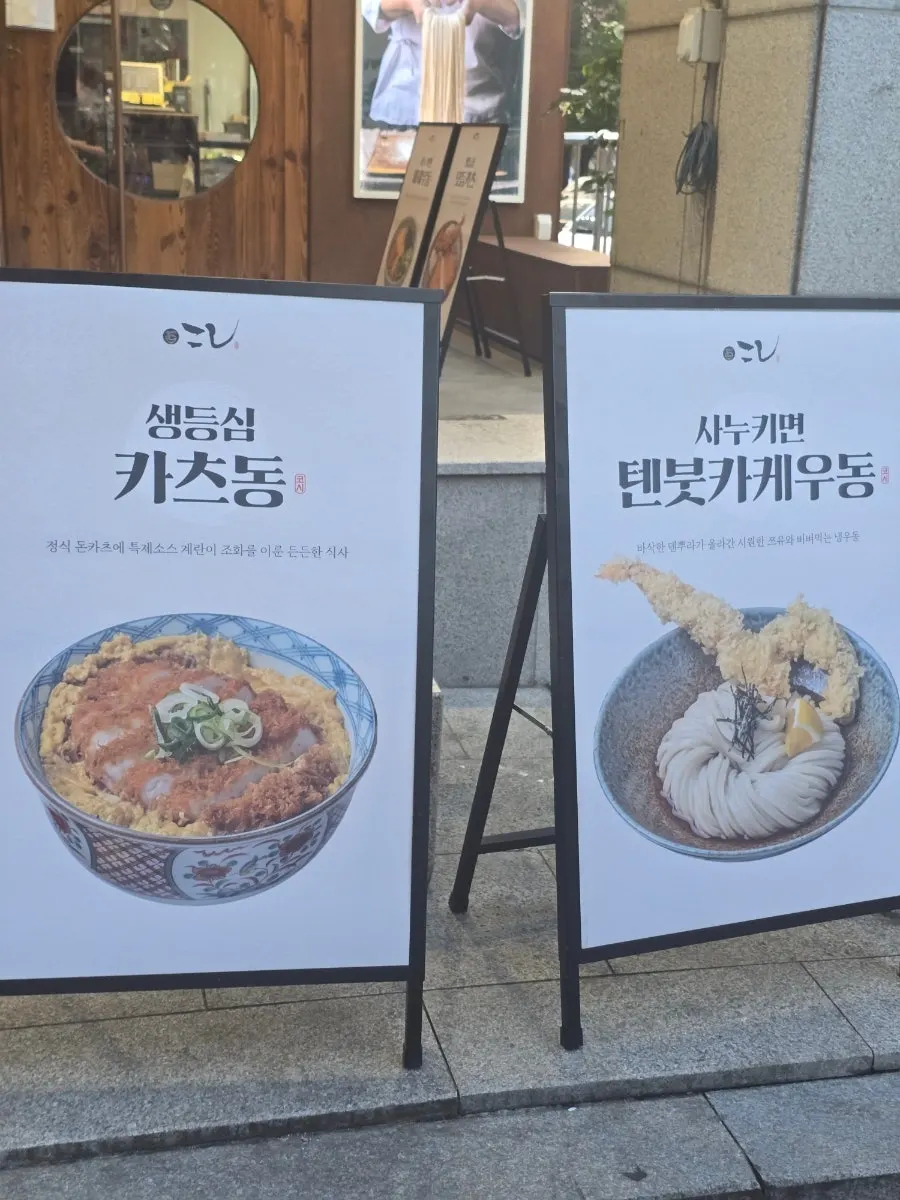 Storefront sign listing fresh pork loin katsudon and tenbukkake udon