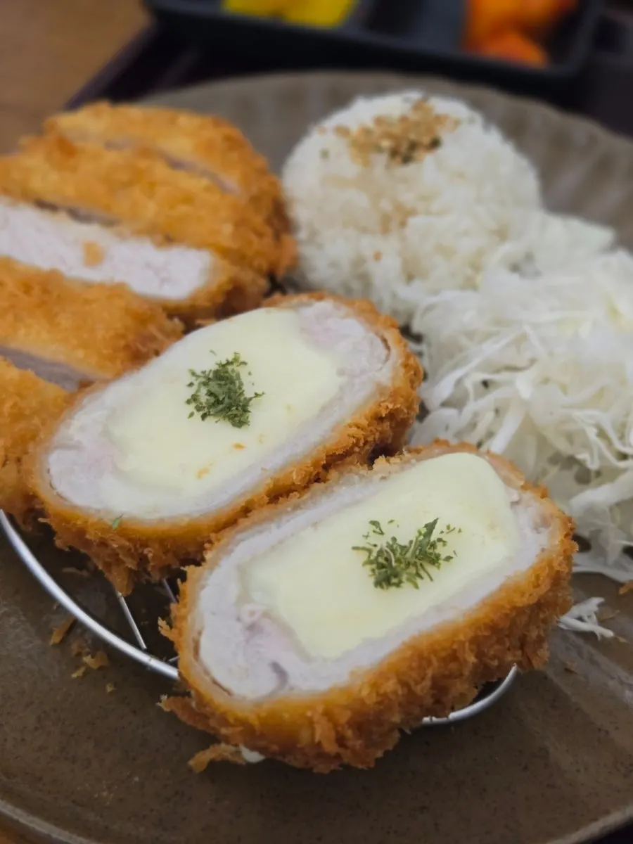 Cheese katsu stretching as it's pulled apart
