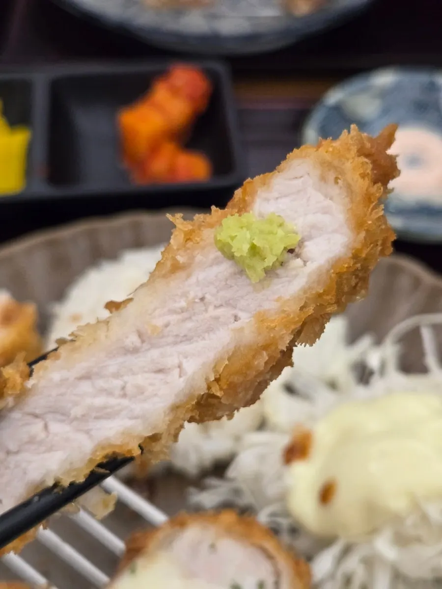 A piece of pork loin katsu topped with wasabi