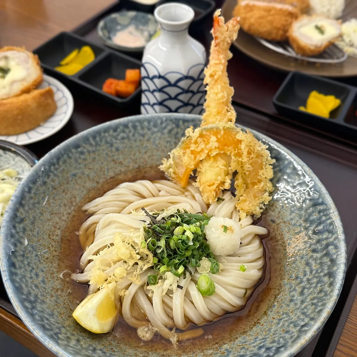 つゆを注ぎ薬味を入れた冷やしうどん