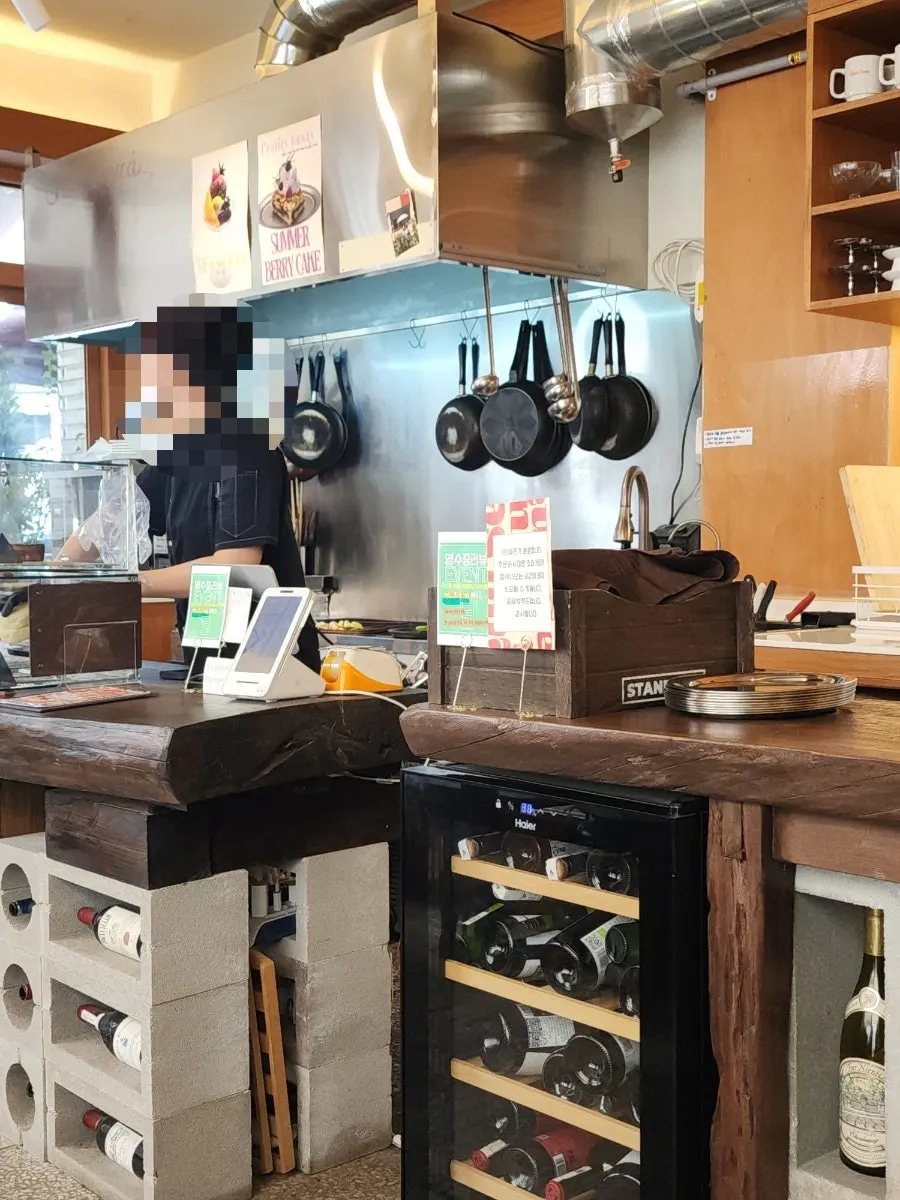 Interior of Que Sera with open kitchen and wine on display