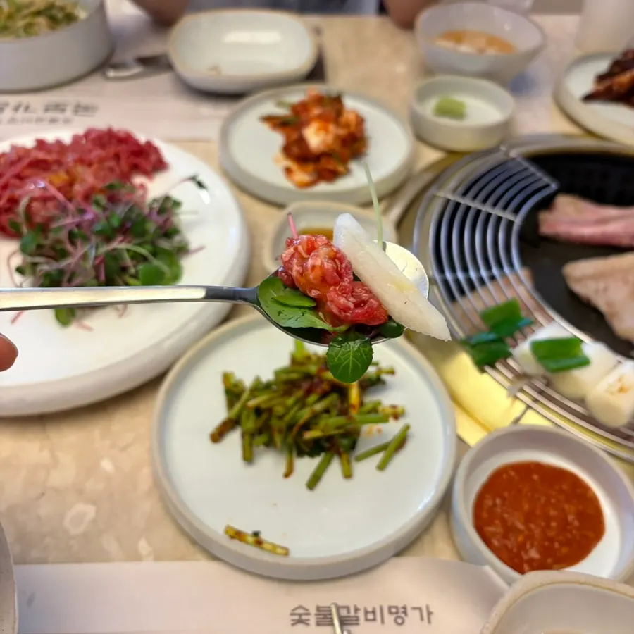 A bite of hanwoo tartare lifted with chopsticks