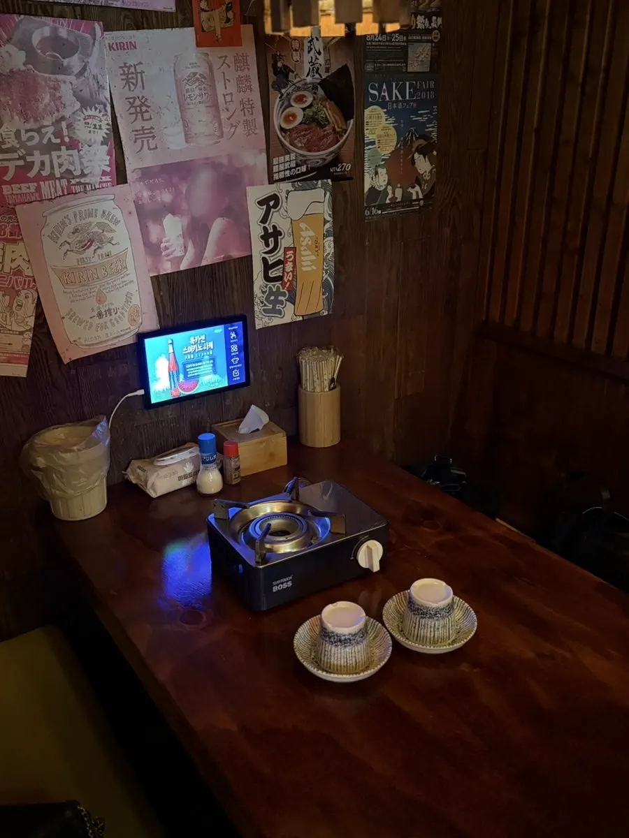 Izakaya entrance with red lanterns and retro posters