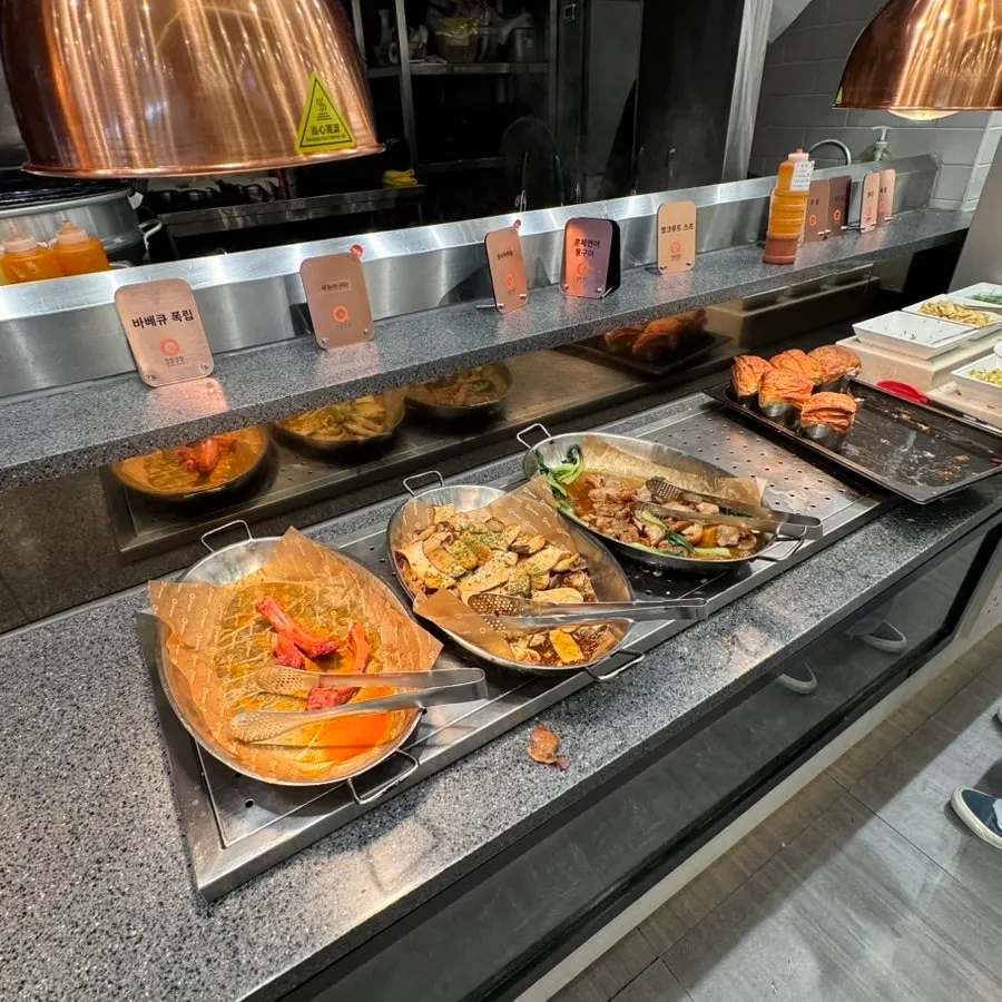 Buffet corner with pork ribs, fried items, and seafood dishes