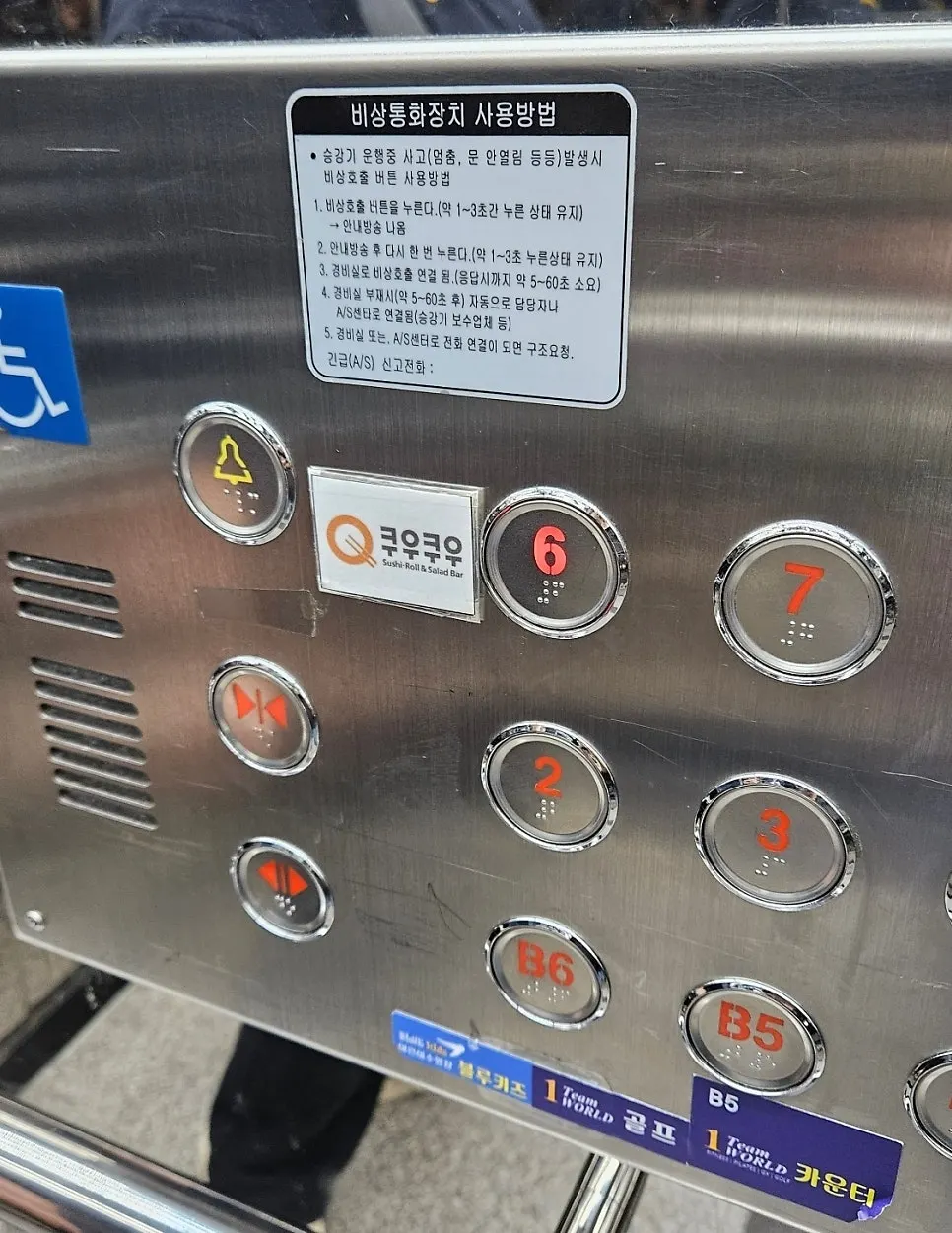 Papan penunjuk lantai dengan tanda Kuu Kuu di lift