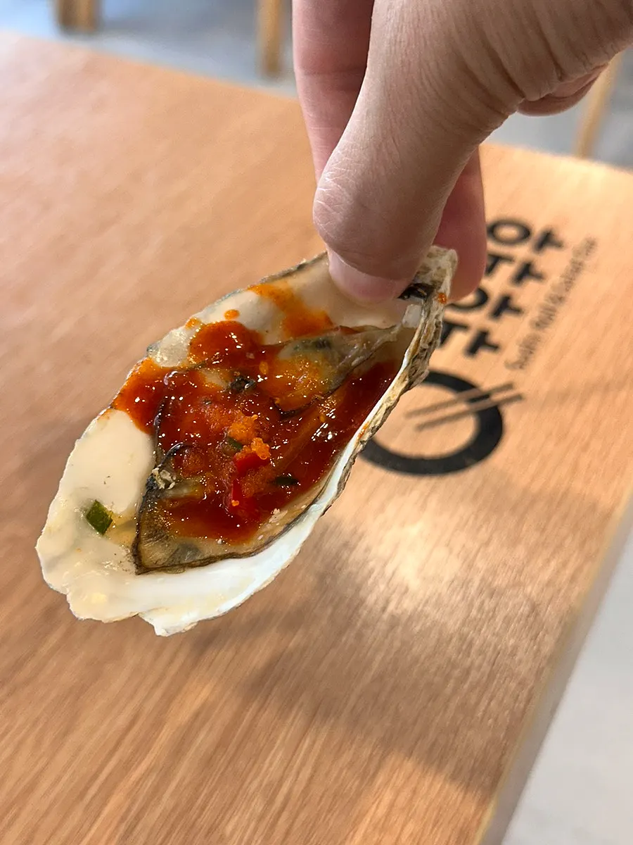 Grilled oysters topped with sauce