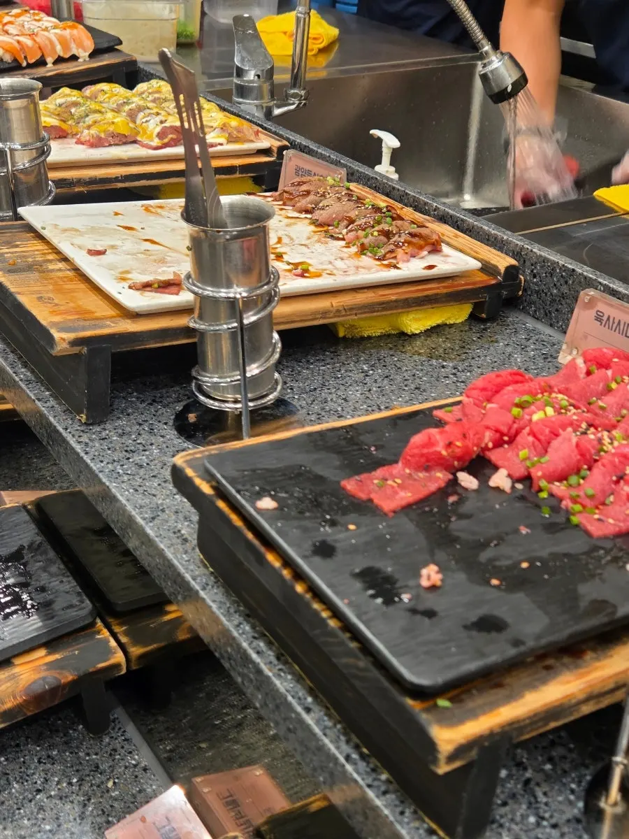Sushi buffet counter lined with many varieties