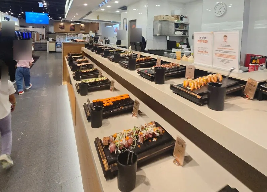 Sushi display case with salmon, shrimp and rolls
