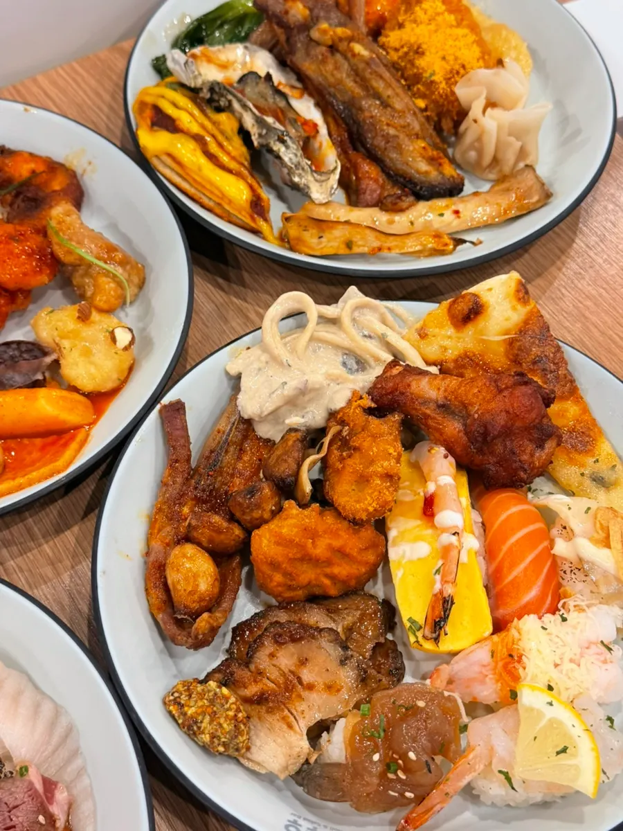 A table full of food brought back from the Kuu Kuu buffet
