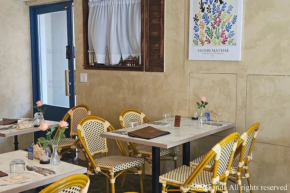 Seating at LA RUELLE lit by sunlight through the windows