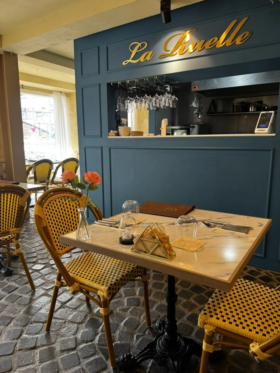 LA RUELLE's interior with a single flower on each table